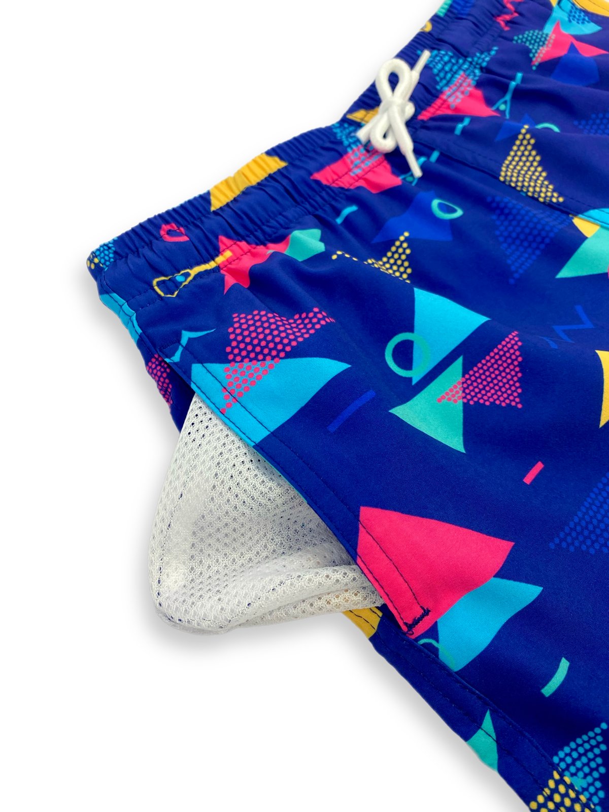 Close-up detail of side pocket showing white quick-dry mesh lining on retro geometric boardshorts