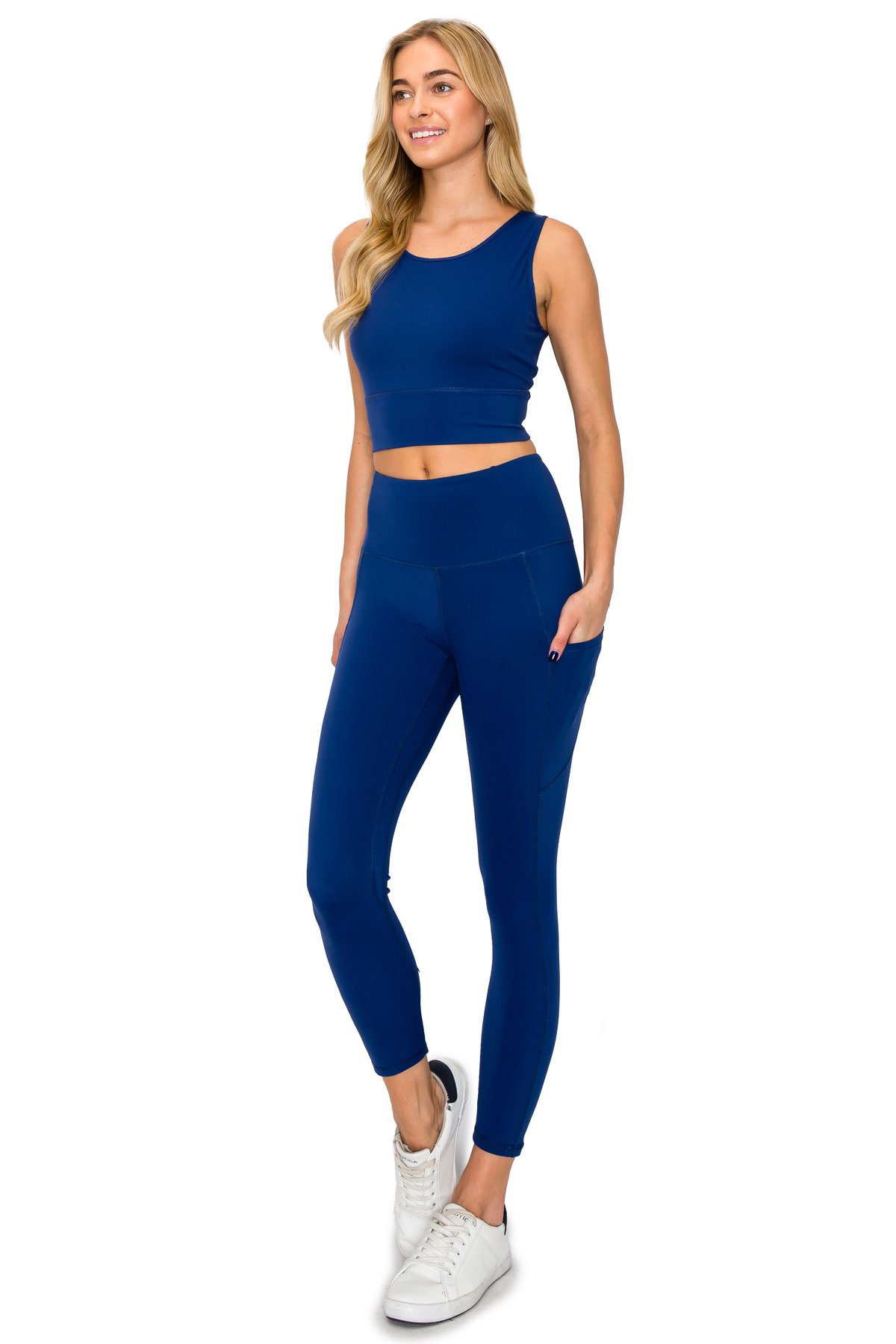 Model showcasing a royal blue activewear set featuring high-waisted pocket leggings and a high-neck crop top.
