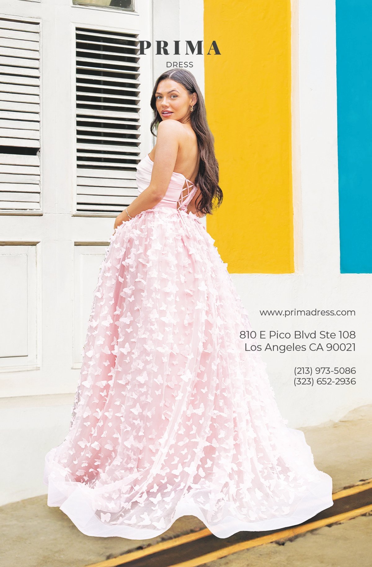 Prima Dress catalog cover featuring model in a pink butterfly applique ballgown against vibrant yellow and blue architecture.